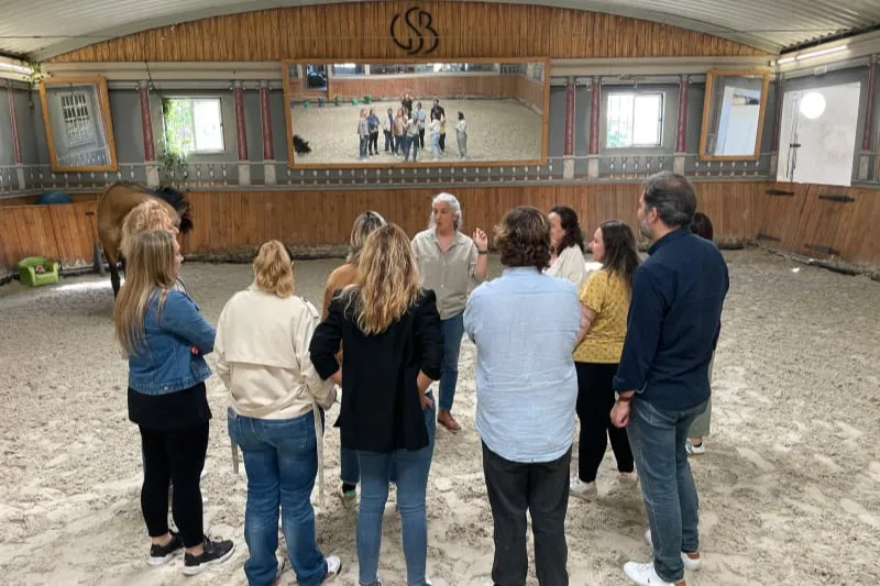 Grupo de 10 pessoas, na areia, pronto para o workshop