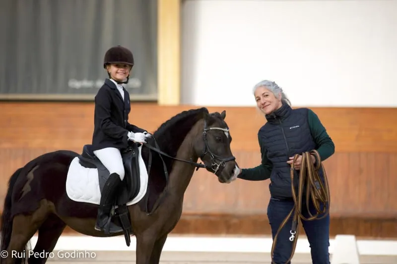 Pônei em competição, sua jovem amazona do dia e a treinadora
